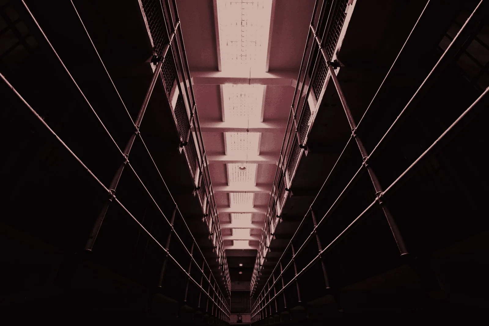Galeria de celas de uma penitenciária, em perspectiva e na penumbra
