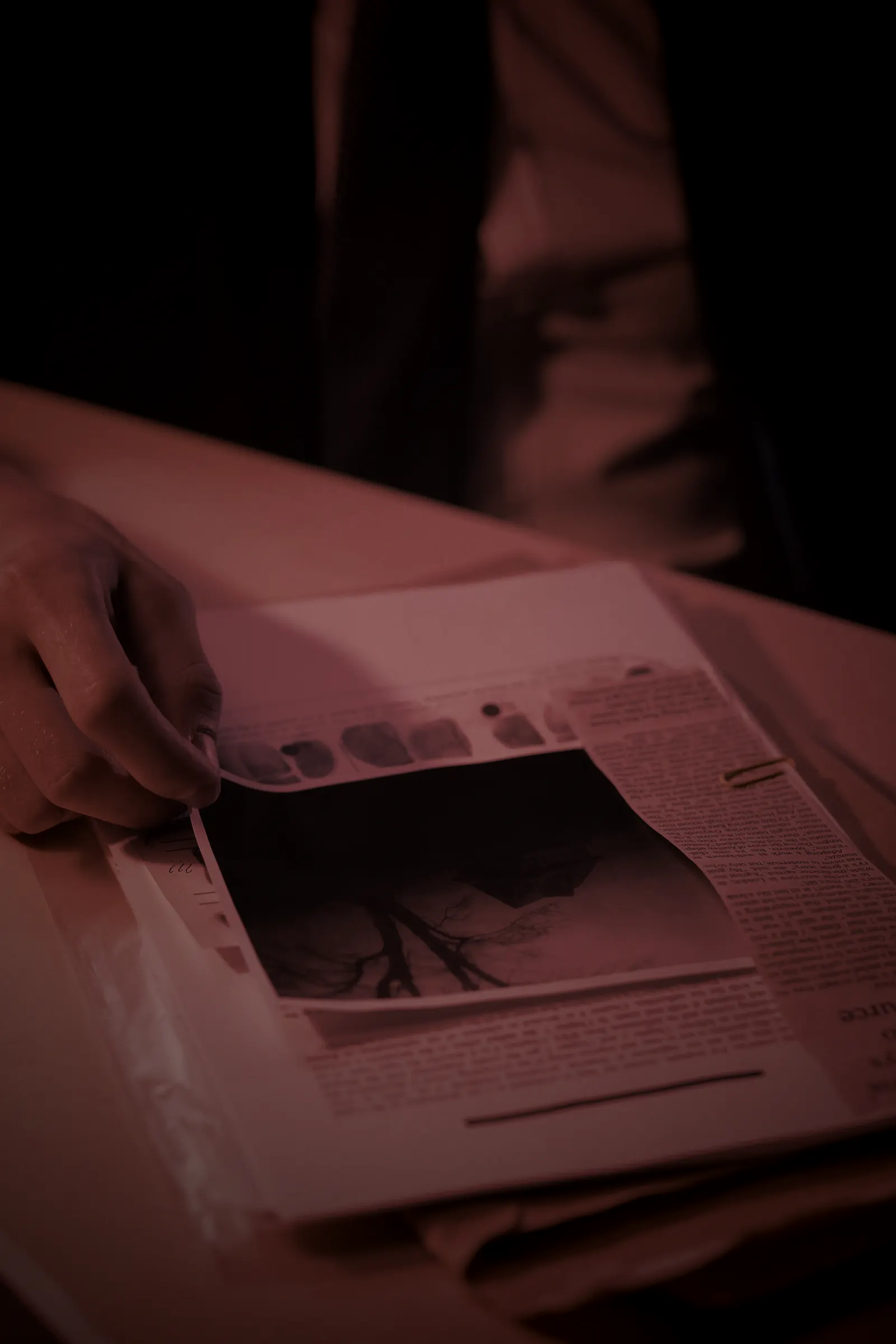 Mãos de terno sobre ficha de impressões digitais e documentos de investigação